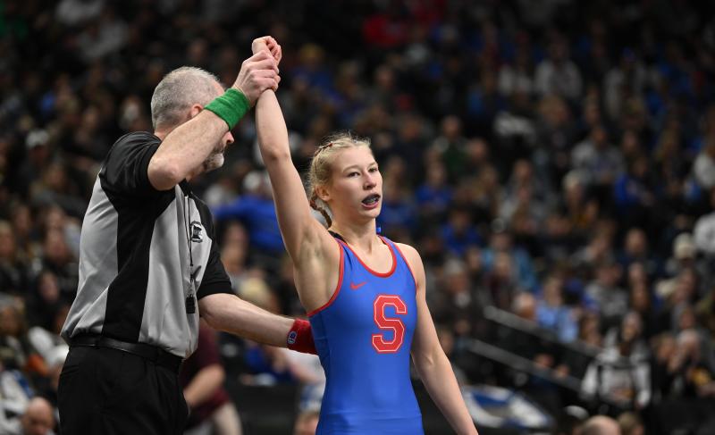 Simley's Charli Raymond's hand is raised after a wrestling victory.